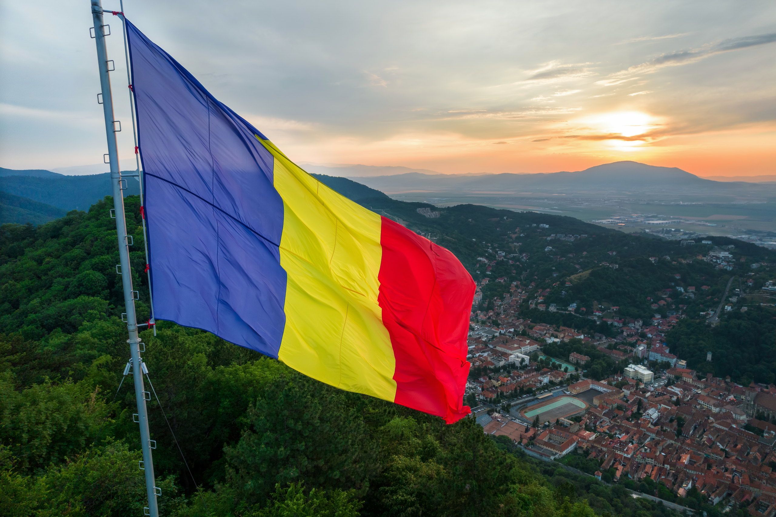The Romanian flag on a hilltop above Brașov at sunset